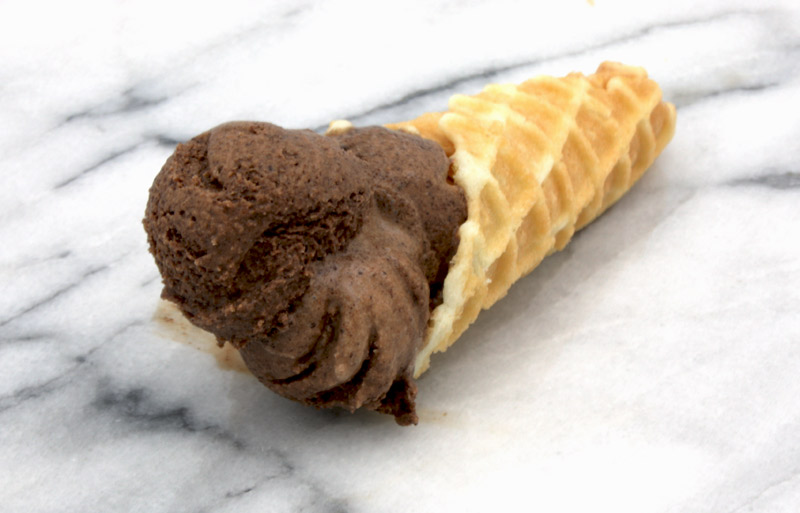 Ben & Jerry's Chocolate Ice Cream A photo of chocolate ice cream in a waffle cone on a marble slab.