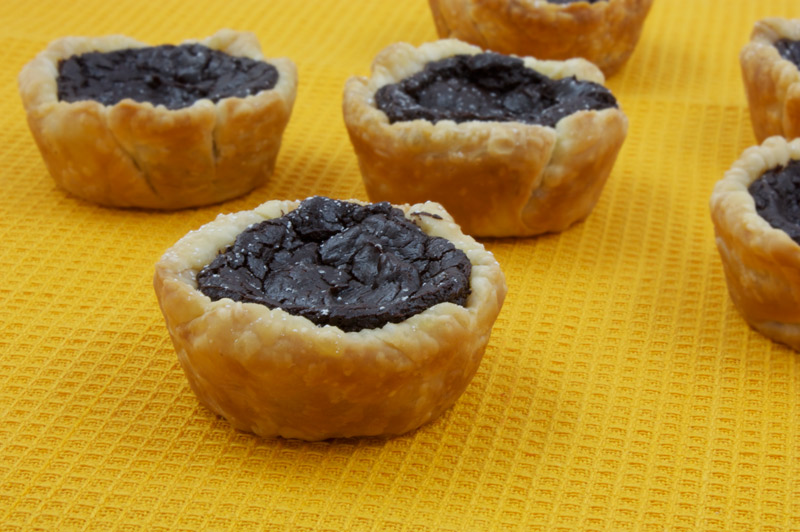 Chocolate Custard Tartlettes A photo of a bunch of a chocolate custard tartlettes on an orange napkin.