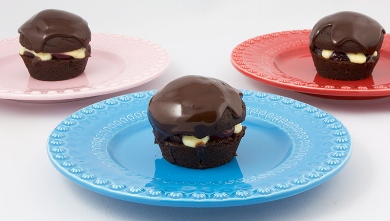 Martha Stewart's Black Forest Cupcakes A photo of 3 black forest cupcakes on a white, pink and red plates.
