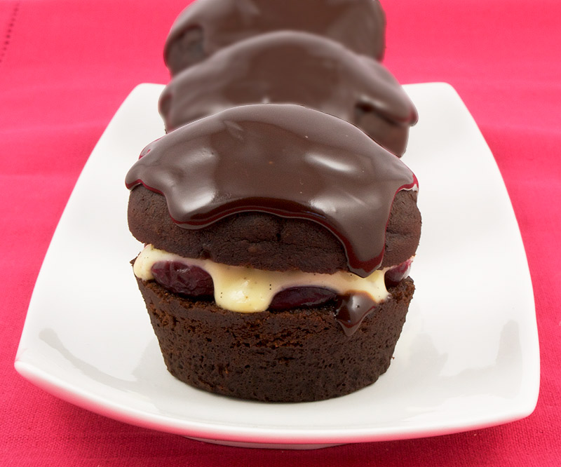 Martha Stewart's Black Forest Cupcakes A photo of 3 black forest cupcakes on a white plate, placed on a pink placemat.