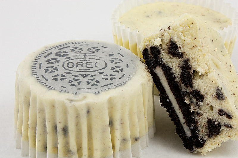 Oreo cookies and cream cheesecakes, Martha Stewart's cookies and cream cheesecakes recipe, easy recipe for Oreo cookies and cream cheesecake cupcakes A photo of 3 Oreo cookies and cream cheesecakes, 1 upside down with Oreo cookie facing up, 1 right side up, and one cut in half.