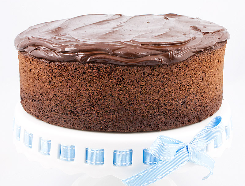 easy chocolate mud cake recipe, dark chocolate ganache recipe, recipe for sweet glazed cherries A photo of Chocolate Mud Cake with Dark Chocolate Ganache on a white cake stand with a pale blue and white ribbon.