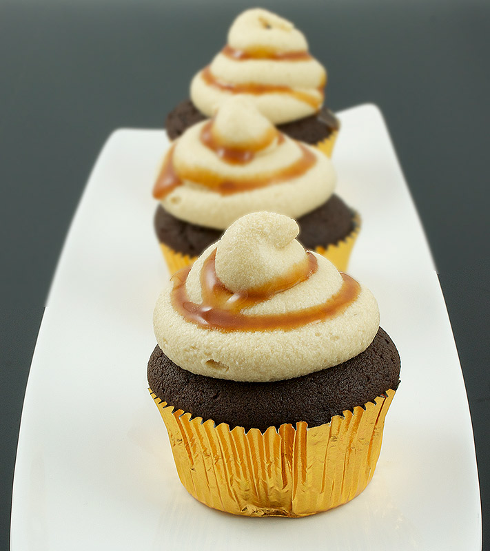 caramel buttercream frosting, quick and easy cupcakes, boozy cupcakes A photo of 3 Caramilk® Cream-Vodka Cooler Cupcakes with Caramel Buttercream Icing.