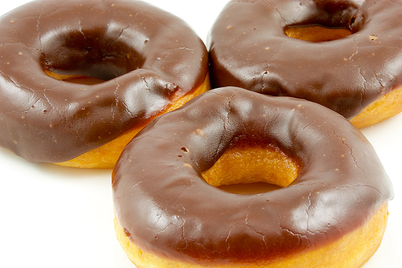 how to make doughnuts at home, doughnut recipe, chocolate doughnut glaze A close up photo of 3 chocolate glazed donuts.