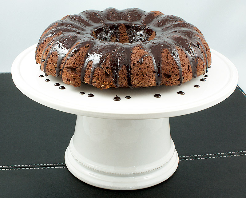 chocolate cake recipes from scratch, chocolate glaze bundt cake, sour cream bundt cake A photo of Donna Hay's Butterscotch-Glazed Chocolate Bundt Cake displayed on a white cake stand.