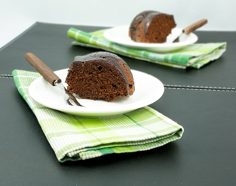 chocolate bundt cake recipe, bundt cake recipes, bundt cake recipe A photo of 2 pieces of butterscotch-glazed chocolate bundt cake on white dessert plates with wooden dessert forks.