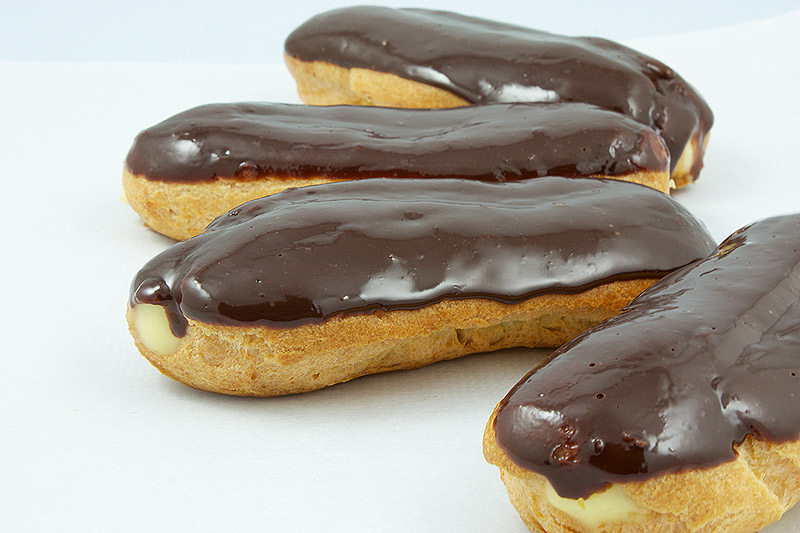 choux pastry recipe, ganache glaze, pastry cream recipe A photo of Chocolate Éclairs with Vanilla Bean Crème Pâtissière and Chocolate Ganache Glaze french pastries arranged in a semi circle.