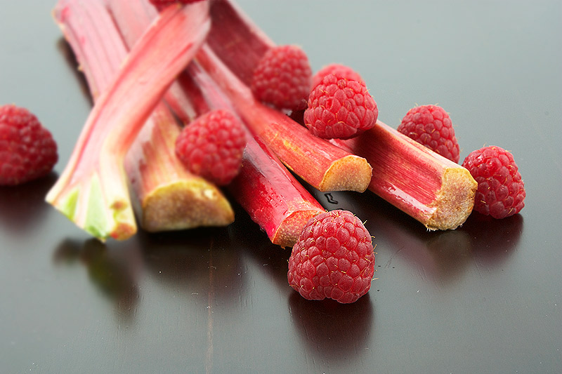 easy crumble topping, easy fruit crumbles, desserts with photos A photo of a handful of rhubarb stalks with a few raspberries.