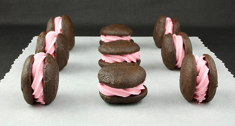 whoopie pie filling, whoopie pie filling recipe, whoopie pie recipes A photo of Chocolate Whoopie Pies with Vanilla Swiss Meringue filling arranged on a wooden tray.