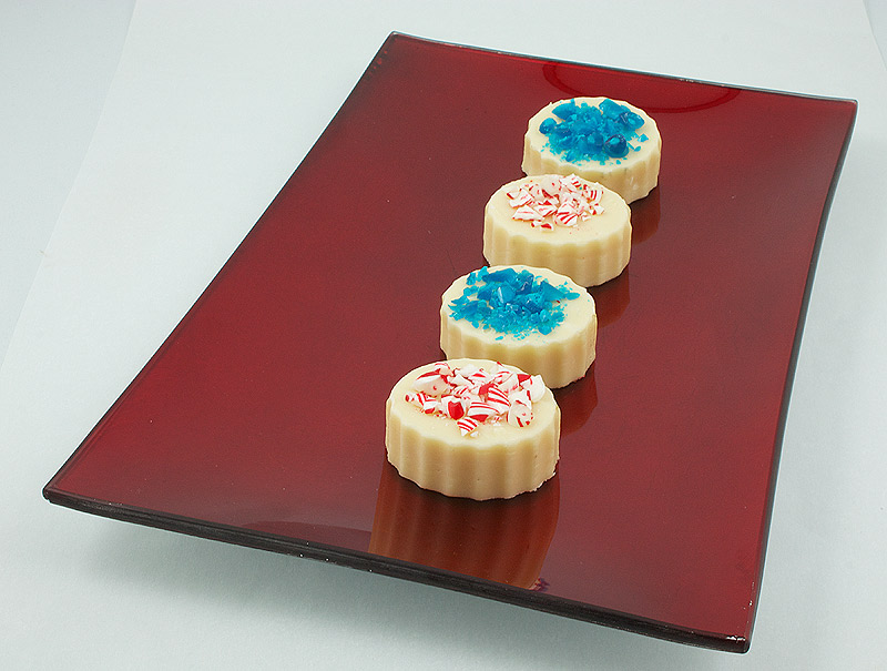 white chocolate fudge, homemade fudge recipe, simple fudge recipe A photo of 4 pieces of Holiday Fudge placed in a row on a red rectangular plate.