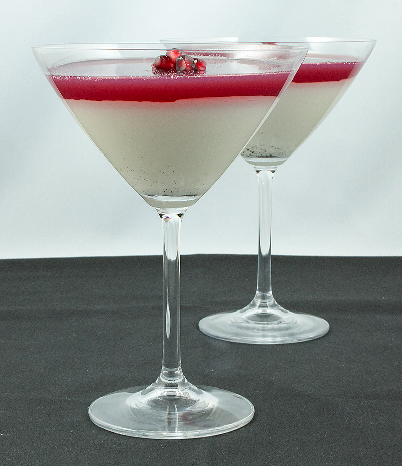 Vanilla-Coconut Panna Cotta with Pomegranate Jelly A photo of 2 Vanilla-Coconut Panna Cotta with Pomegranate Jelly layered desserts garnished with a few pomegranate seeds and served in martini glasses.