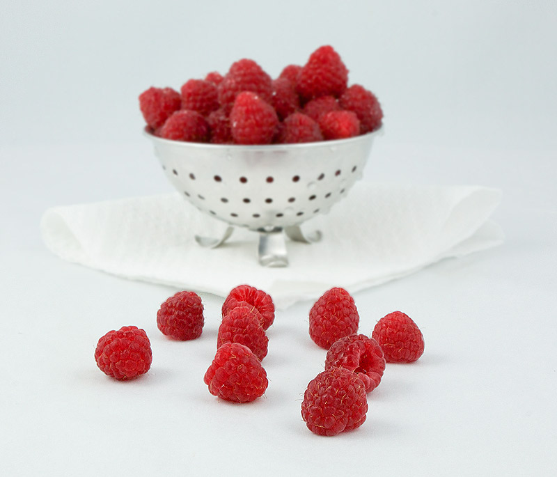 Raspberries A photo of fresh raspberries in a colander, used for garnishing a chocolate mousse dessert.