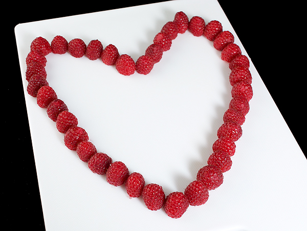 Raspberries, raspberry jam recipes, how to make raspberry jam A photo taken looking down at fresh raspberries arranged in the shape of a heart.