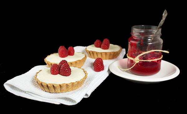 white chocolate raspberry tart recipe, white chocolate and raspberry tart recipe, white chocolate ganache recipe A photo of White Chocolate Raspberry Tarts displayed with homemade raspberry jam.