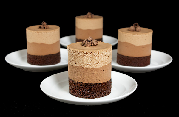 Chocolate Mousse Cakes A photo of 4 Chocolate Mousse Cakes on small, white dessert dishes.