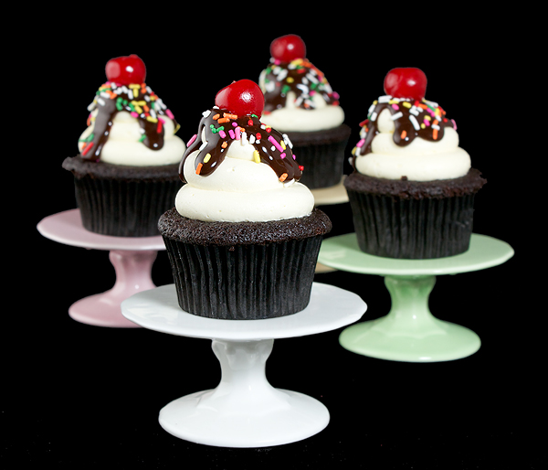 Hot Fudge Sundae Cupcakes A photo of four Hot Fudge Sundae Cupcakes on individual cupcake stands.
