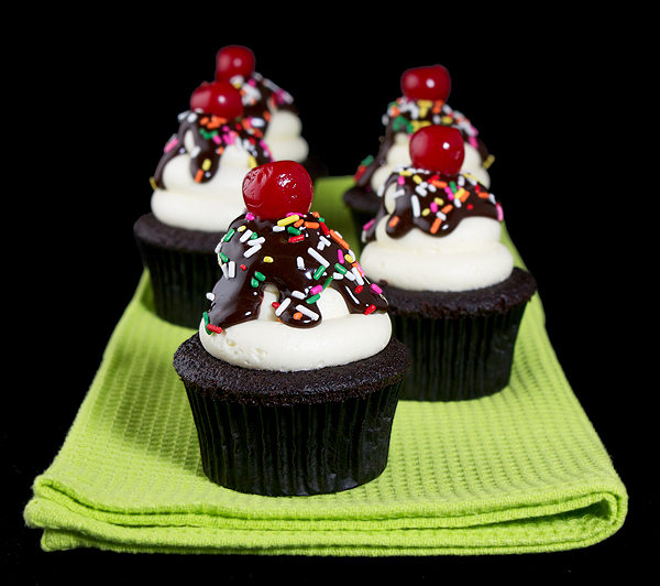 Chocolate Cupcakes with Fluffy Vanilla Frosting A photo of Chocolate Cupcakes with Fluffy Vanilla Frosting decorated to resemble Hot Fudge Sundaes with Chocolate Ganache, colourful sprinkles and topped with a maraschino cherry.