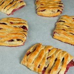 easy breakfast recipes, pastry recipes, danish cheese, danish recipes A photo taken looking down on Cheese Danishes with fresh strawberries displayed on parchment paper.