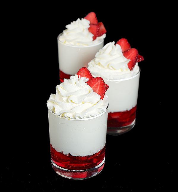 Strawberry Shortcake Trifle A photo of 3 Strawberry Shortcake Trifle desserts garnished with fresh strawberries.