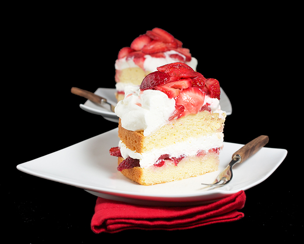 Strawberry and Cream Cake A photo of two slice of Strawberry and Cream Cake on white dessert dishes.