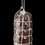 A photo of Salame al Cioccolato (Chocolate Salami) hanging and decorated to resemble Savoury Salami.
