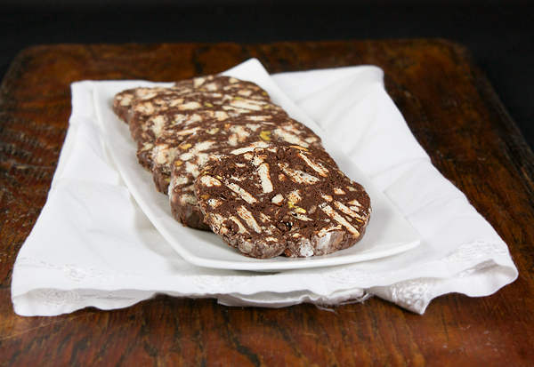 Italian Chocolate A photo of an Italian Chocolate dessert, Chocolate Salami cut in slices and displayed on a white rectangular dish.