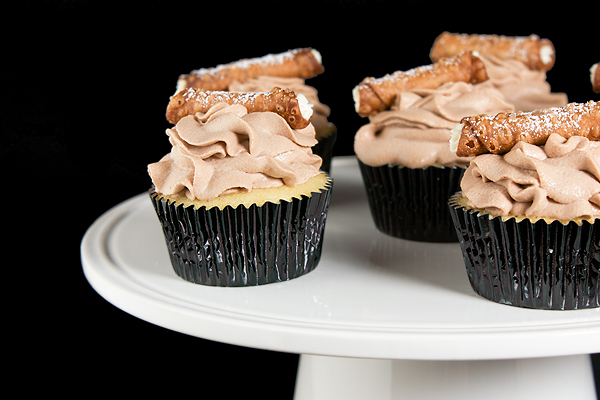 Italian Cake, vanilla cupcake, vanilla cupcake recipe A photo of Cannoli Cupcakes displayed on a white cake stand.