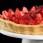 A photo of an Italian Dessert, Crostata di Fragole con Crema Pasticcera e Chantilly {Strawberry Tart} displayed on a white cake stand.