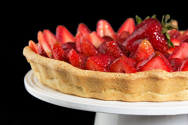 A photo of an Italian Dessert, Crostata di Fragole con Crema Pasticcera e Chantilly {Strawberry Tart} displayed on a white cake stand.