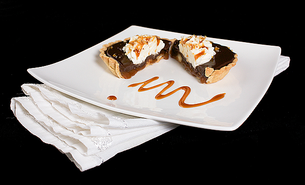 tart filling, making caramel, recipe caramel A photo of a Chocolate Caramel Tart sliced in half to reveal the inner layers of caramel, hazelnuts, dark and milk chocolate ganache and milk chocolate glaze.
