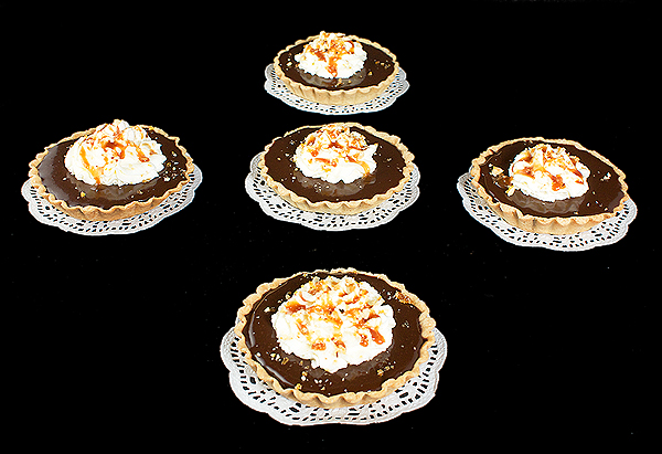 Chocolate Tart A photo of Chocolate Tarts with Caramel displayed on white doilies.