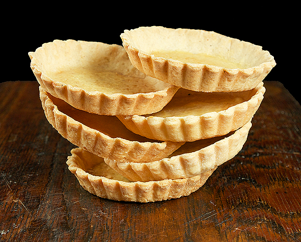 Pasta Frolla Tart Shells A photo of Pasta Frolla Tart Shells displayed on a dark wooden board.