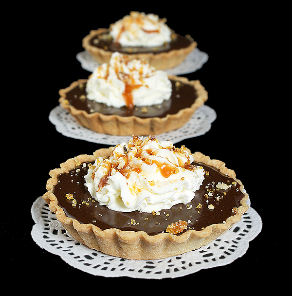 Chocolate-Caramel Tart {Tartellette al Cioccolato e Caramello} A photo of Italian Desserts, Tartellette al Cioccolato e Caramello (Chocolate-Caramel Tarts) presented on white doilies.