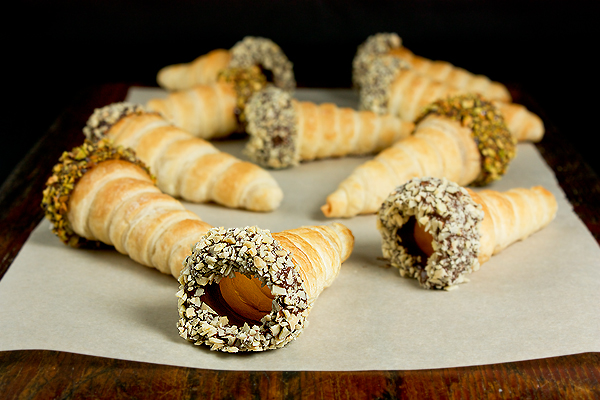 Puff Pastry Horns A photo of Puff Pastry Horns dipped in melted chocolate and rolled in toasted nuts - pistachio, almonds and hazelnuts.