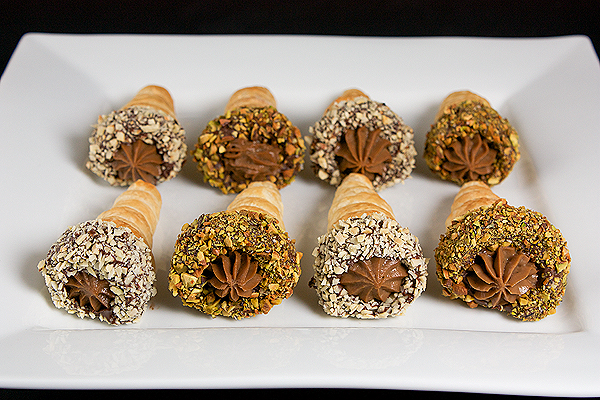 pastry Italian, crema pasticcera, pastry cream recipe A photo of Italian Pastries, Chocolate Pastry Cream filled Puff Pastry Horns displayed on a square, white dish.