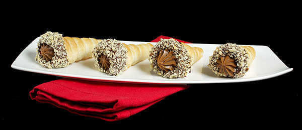 Italian Pastries A photo of Italian Pastries, Cannoncini filled with Chocolate Pastry Cream and rolled in melted chocolate and coated with toasted nuts.