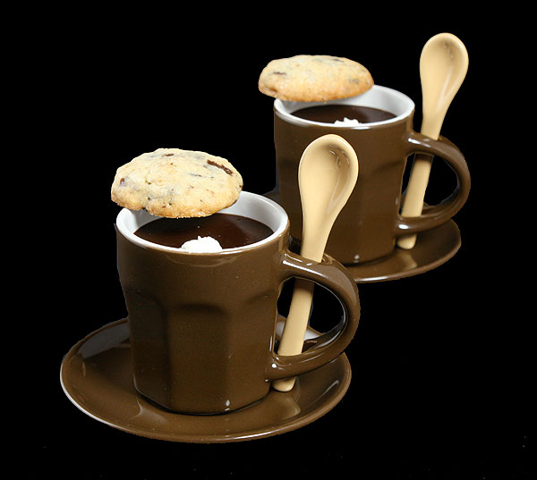 chocolate pudding dessert A photo of a French chocolate pudding dessert, pots de creme au chocolat, garnished with whipped cream and served in chocolate brown espresso cups with a chocolate hazelnut cookie placed on the rim of the cup.