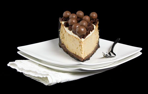 Grace's Sweet Life Coffee Cheesecake A photo of a slice of Coffee Cheesecake on two stacked white dessert dishes on a white cloth napkin with a dessert fork.