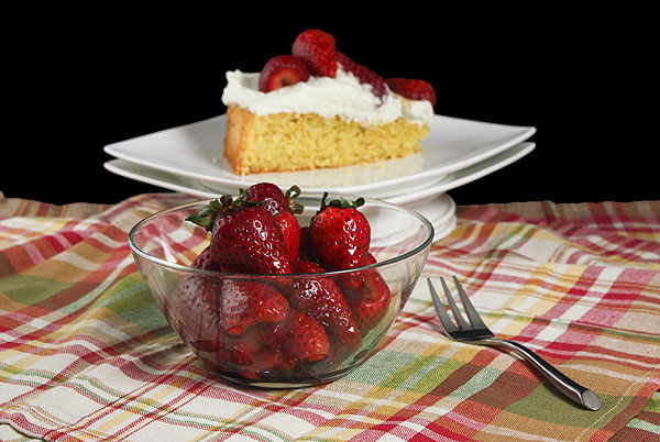 Grace's Sweet Life Recipes with Cornmeal A photo of a bowl of Balsamic Strawberries with a slice of Italian Cornmeal Cake set in behind.