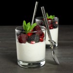 Grace's Sweet Life Buttermilk Cream A photo of two Buttermilk Cream desserts in glasses with fresh mixed berries, pomegranate seeds and a sprig of mint.