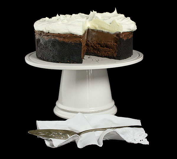 Chocolate Pie A photo of a Chocolate Pie with a slice removed displayed on a white cake stand with an antique cake server.
