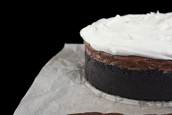 Mississippi Mud Cake A close up, cropped photo of half a Mississippi Mud Cake on a sheet of parchment paper.