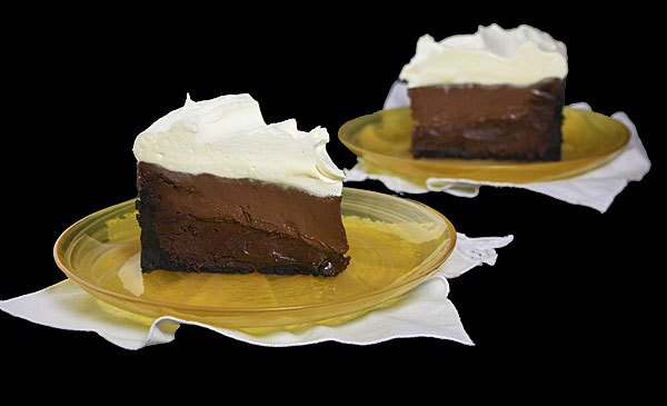 Mud Cake Recipe A photo of two slices of Mudcake on yellow dessert dishes with white cloth napkins.
