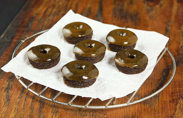 Caramel Glazed Donuts from Grace's Sweet Life A photo of Mini Cake Donuts dipped in Salted Caramel Glaze cooling on a parchment paper lined mini wire rack.