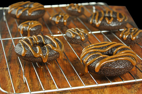 Dark Chocolate Cake Donuts with Salted Caramel A photo of Dark Chocolate Cake Donuts with Salted Caramel Glaze cooling on a wire rack.