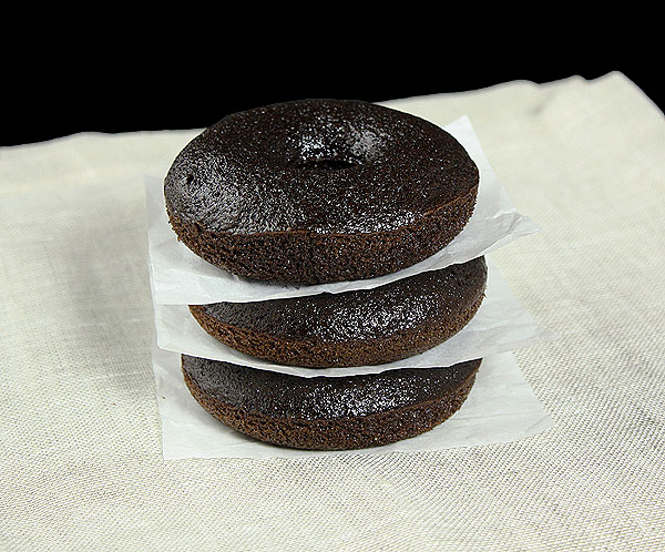 Grace's Sweet Life Cake Donuts A photo of a stack of Cake Donuts separated by parchment paper squares.