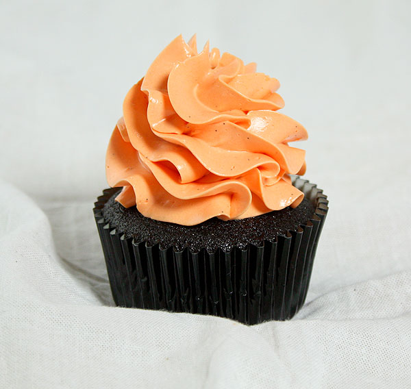 Grace's Sweet Life Chocolate and Pumpkin A close up photo of a Chocolate and Pumpkin Cupcake decorated with orange-tinted Vanilla Bean-Swiss Meringue Buttercream.