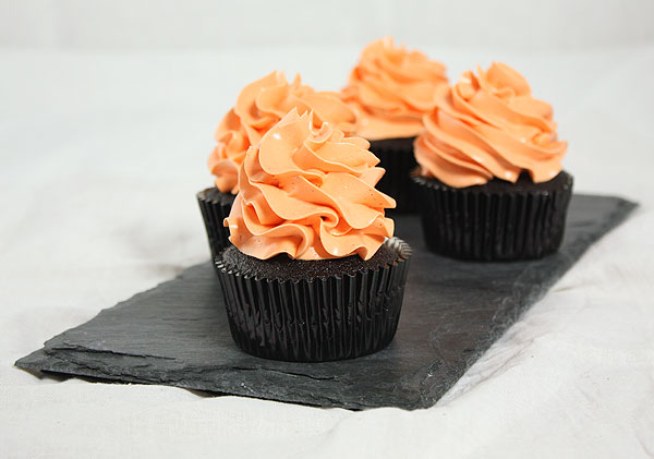 Grace's Sweet Life Dark Chocolate Pumpkin Cupcakes A photo of four Dark Chocolate Pumpkin cupcakes on a slate board.