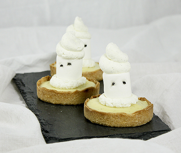A photo of three Ghost Tarts displayed in a row on a rectangle shaped slate board.