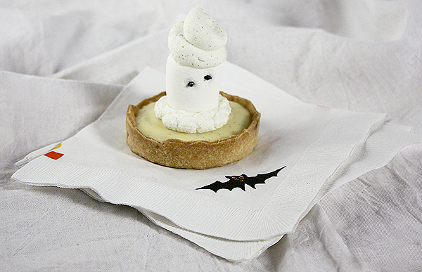 A photo of a Marshmallow Ghost Tart displayed on paper Halloween bat napkins.
